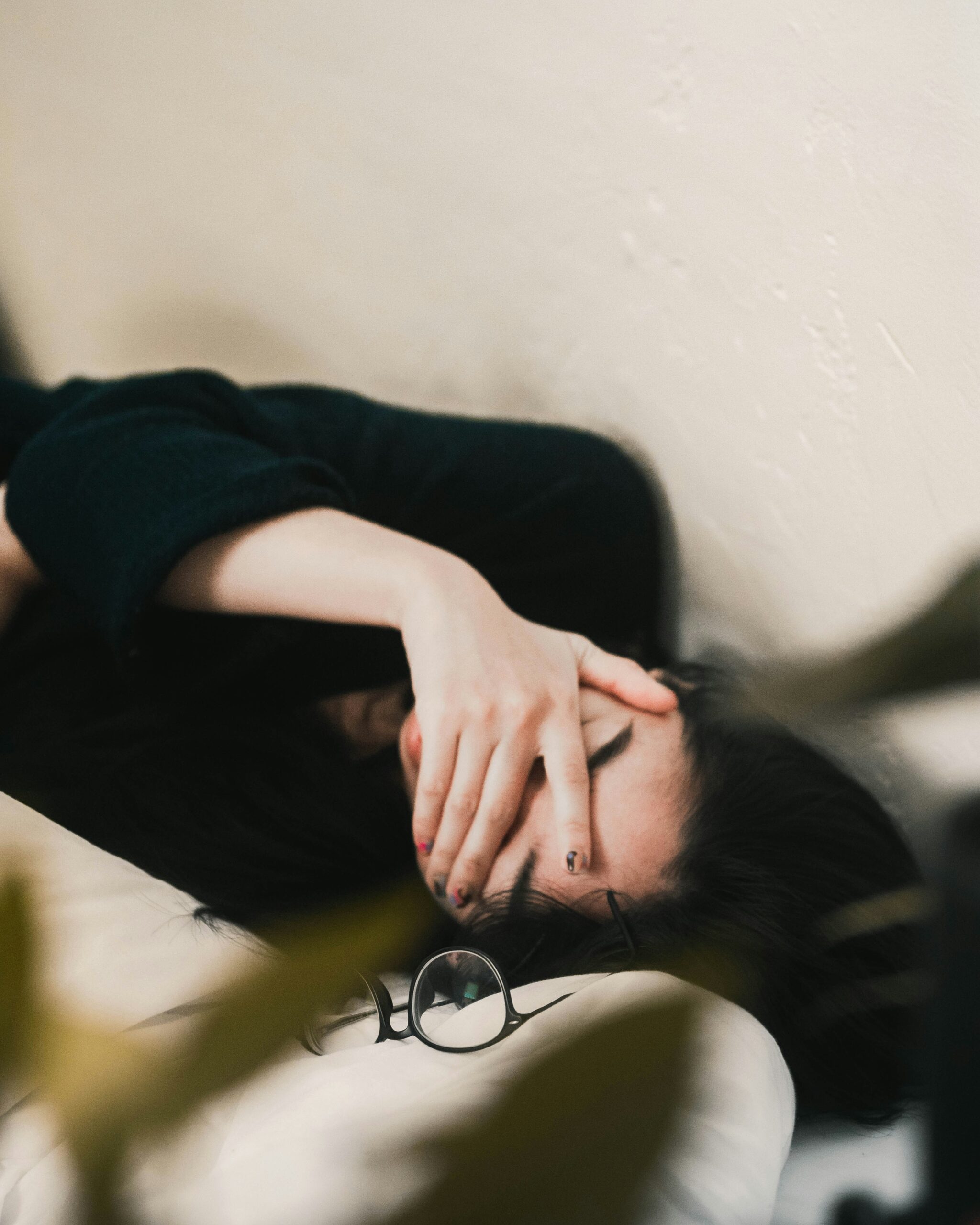 Exhausted woman resting with her eyes covered, a common sign of persistent low energy