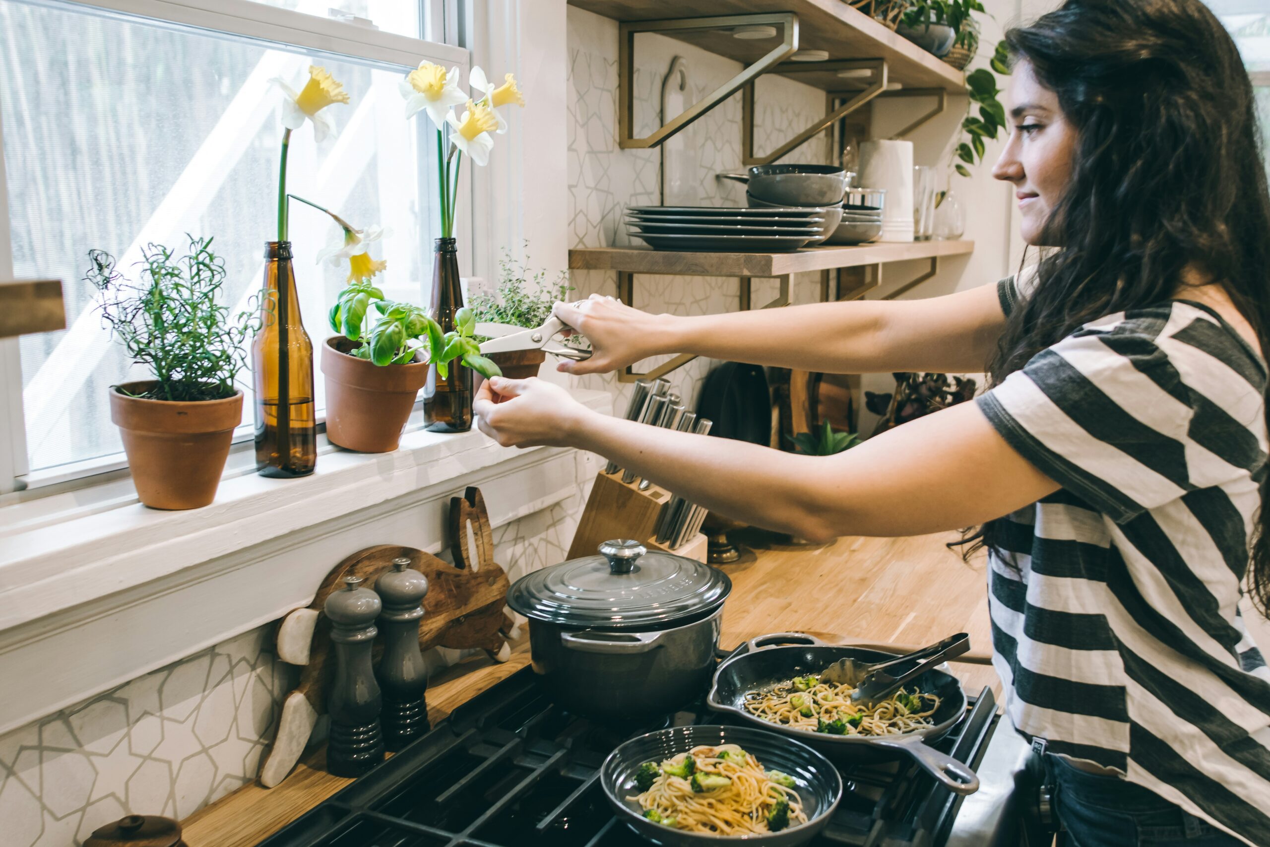 Woman preparing a protein-rich meal with vegetables, representing a PCOS and nutrition approach to managing symptoms